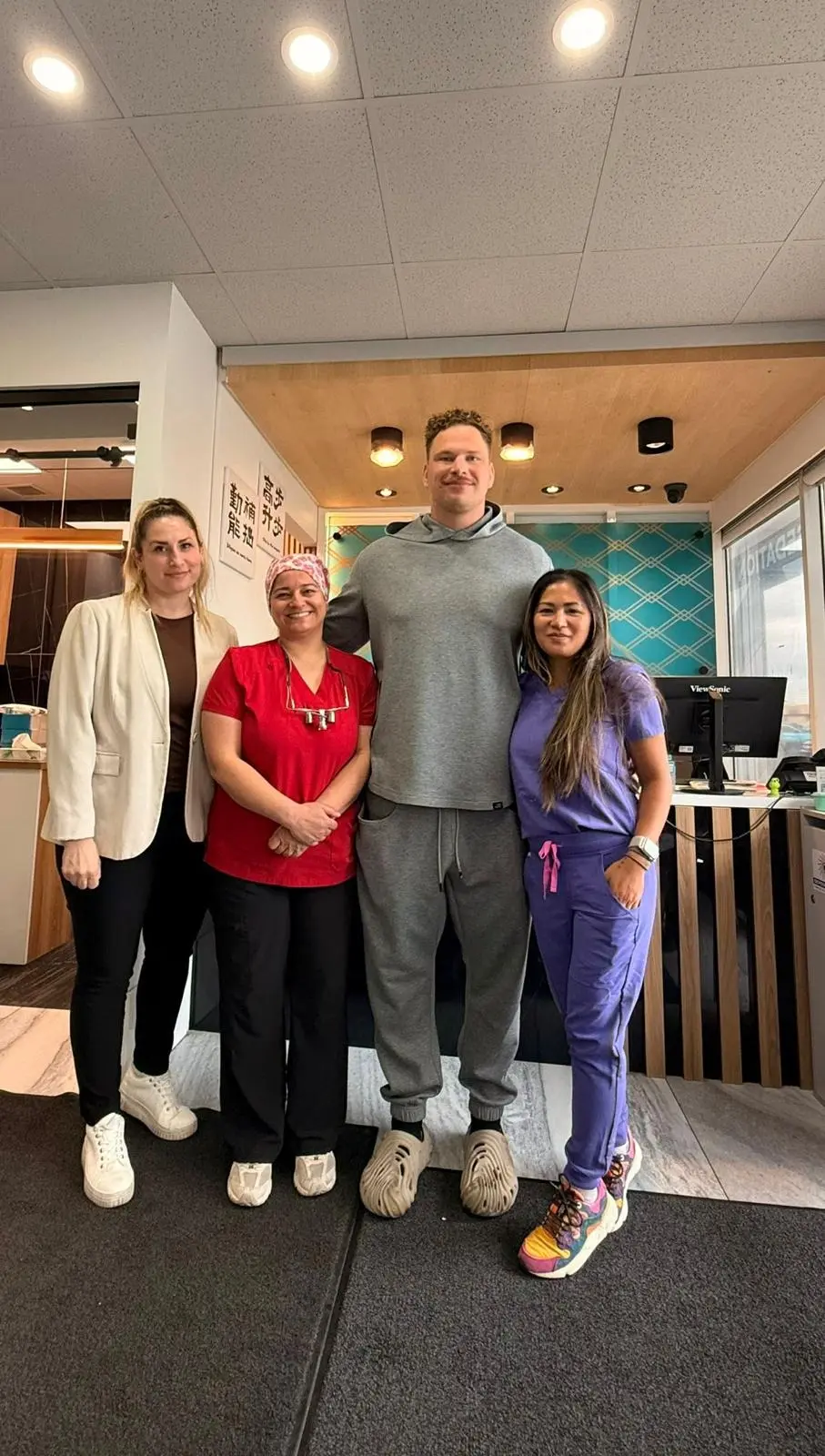 Zack Williams, Calgary Stampeders offensive lineman, with the London Square Dental Centre care team at our Calgary clinic